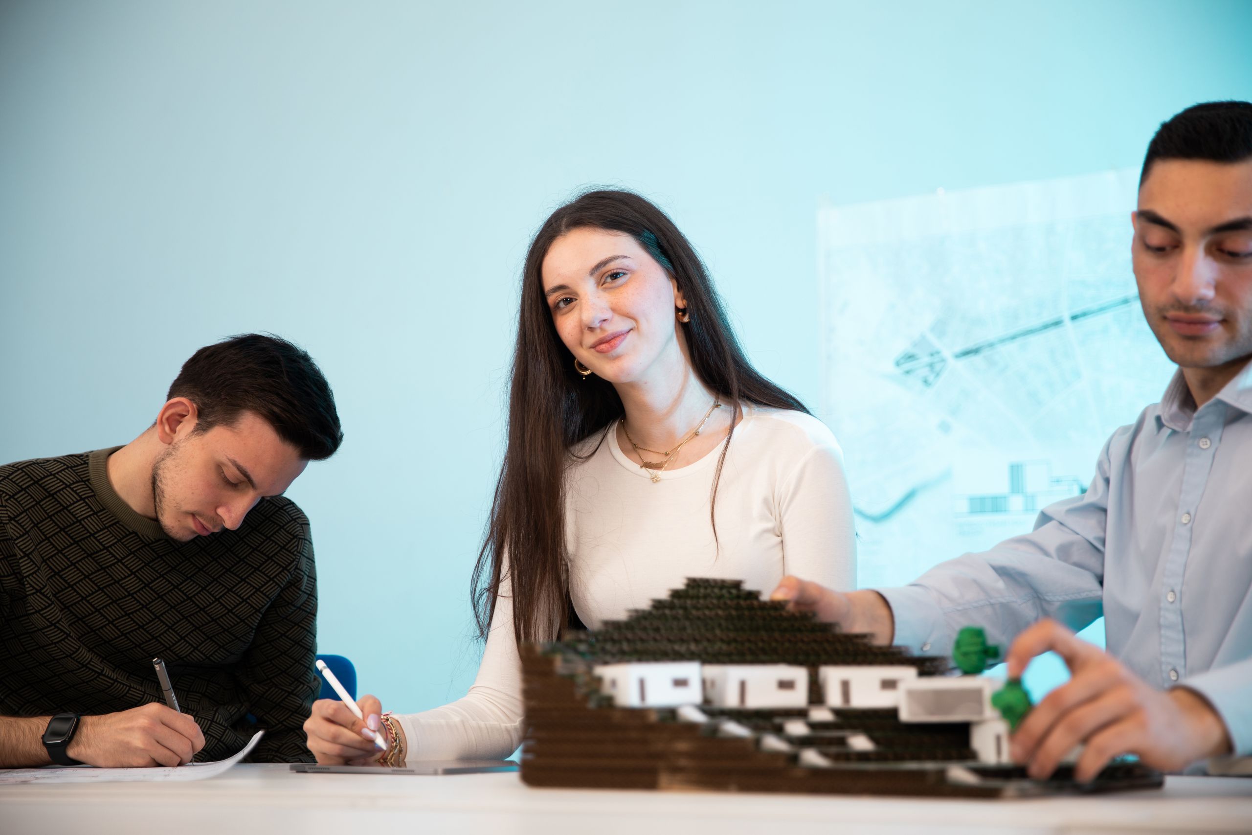 Prospective buyers reviewing an architectural model at a presentation centre